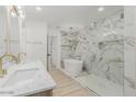 Modern bathroom with marble tile, a freestanding tub, and a glass-enclosed shower at 126 E Northern Ave, Phoenix, AZ 85020