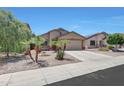 Charming single-story home featuring desert landscaping, a two-car garage, and a welcoming facade at 1384 S 222Nd Ln, Buckeye, AZ 85326