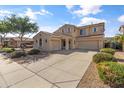 Well maintained two-story home with three car garage, lush landscaping, and extended driveway at 15046 W Post Dr, Surprise, AZ 85374