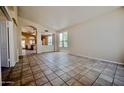 Expansive living room featuring tile floors, arched doorways, and abundant natural light at 20443 N 39Th Dr, Glendale, AZ 85308