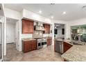 Gourmet kitchen features stainless steel appliances, granite countertops, tile backsplash, and wood cabinetry at 31502 N 58Th Pl, Cave Creek, AZ 85331