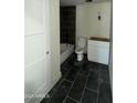 Bathroom featuring dark tile flooring, tub and white vanity with toilet at 3725 E Karen Dr, Phoenix, AZ 85032