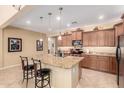 Bright, updated kitchen features stainless appliances and a large center island with barstool seating at 42709 W King Fisher Dr, Maricopa, AZ 85138