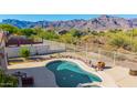 Aerial view of a beautiful pool with desert landscaping and mountain views at 4297 S Pony Rider Trl, Gold Canyon, AZ 85118