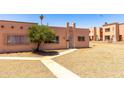 Front view of a one-story desert home with a tidy sidewalk and a shade tree at 4625 W Thomas Rd # 50, Phoenix, AZ 85031