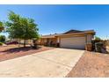This charming single-story home offers an inviting driveway leading to a well-maintained property at 617 E Calle Adobe Ln, Goodyear, AZ 85338