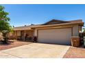 Single-story home featuring a two-car garage and low-maintenance landscaping at 617 E Calle Adobe Ln, Goodyear, AZ 85338