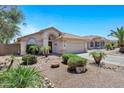 Beautiful home with manicured desert landscaping, mature plants, and neutral colored exterior at 625 W Douglas Ave, Gilbert, AZ 85233