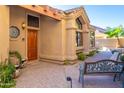 Inviting exterior of the home featuring a beautifully landscaped entryway with a tiled bench and a wooden door at 7525 E Gainey Ranch Rd # 164, Scottsdale, AZ 85258