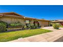 Charming brick house with a manicured lawn and an attached garage under a clear blue sky at 8355 E Vía De Los Libros --, Scottsdale, AZ 85258