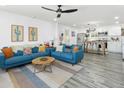 Bright open-concept living room with blue couches, a modern kitchen, and light gray wood floors at 912 E Orchid Ln, Phoenix, AZ 85020