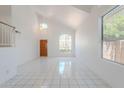 Bright living room with high ceilings and a large window, complemented by white ceramic tile floors at 9371 E Wood Dr, Scottsdale, AZ 85260