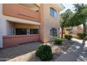 Exterior view of condo building with well-maintained landscaping, balcony, and tan stucco at 10030 W Indian School Rd # 101, Phoenix, AZ 85037