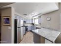 Updated kitchen features modern stainless steel appliances, granite countertops, and a breakfast bar at 10030 W Indian School Rd # 101, Phoenix, AZ 85037