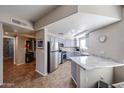 Updated kitchen features modern stainless steel appliances, granite countertops, and recessed lighting at 10030 W Indian School Rd # 101, Phoenix, AZ 85037