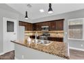 Bright kitchen featuring granite countertops, stainless steel appliances, and dark wood cabinetry at 1332 W Blue Ridge Ct, Chandler, AZ 85248