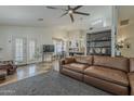 Open living room floor plan featuring a large leather couch, ceiling fan, and tile flooring throughout at 16426 S 29Th St, Phoenix, AZ 85048