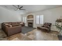 Cozy living room with stone fireplace, two leather couches, tile flooring, and large windows with shutters at 16426 S 29Th St, Phoenix, AZ 85048