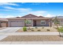 Inviting single-story home with a well-kept front yard, desert landscaping, and a convenient two-car garage at 17051 W West Wind Dr, Surprise, AZ 85387