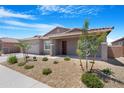 Attractive single-story home featuring desert landscaping, a two-car garage, and a welcoming front entrance at 17051 W West Wind Dr, Surprise, AZ 85387