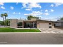 Striking modern home with an attached garage, lush grass, and well-maintained landscaping at 4202 E Catalina Dr, Phoenix, AZ 85018