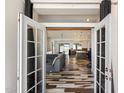 Inviting open-concept living space with stylish flooring, French doors, and abundant natural light at 4202 E Catalina Dr, Phoenix, AZ 85018