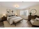 Cozy bedroom featuring a large bed, a bench, neutral colors, and wood-look floors at 5104 N 32Nd St # 114, Phoenix, AZ 85018