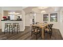 Bright dining room featuring wood floors, a modern table, and views of the kitchen at 5104 N 32Nd St # 114, Phoenix, AZ 85018