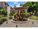 Community entrance featuring a decorative water feature, landscaping and desert flora at 5104 N 32Nd St # 114, Phoenix, AZ 85018