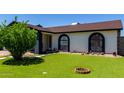 Charming home with tidy front synthetic lawn, manicured landscaping, and decorative accents, showcasing curb appeal at 5432 W Sunnyside Dr, Glendale, AZ 85304