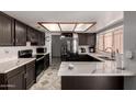 Modern kitchen featuring sleek countertops, dark cabinets, and stainless steel appliances at 5432 W Sunnyside Dr, Glendale, AZ 85304