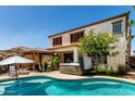 Outdoor living space featuring a refreshing pool, hot tub, and shaded patio, perfect for relaxing at 861 E Indian Wells Pl, Chandler, AZ 85249