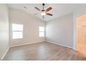Bright main bedroom featuring vinyl floors, a ceiling fan, and en suite bathroom at 8744 W Superior Ave, Tolleson, AZ 85353