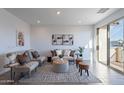Bright and airy living room with a sliding glass door, neutral-toned furniture, and stylish decorative accessories at 9835 E Wavelength Ave, Mesa, AZ 85212