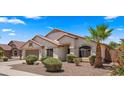 Charming single-story home with desert landscaping, a two-car garage, and a well-maintained lawn at 10046 E Posada Ave, Mesa, AZ 85212