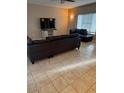 Living room with tile floors, a leather sofa, a wall-mounted television, and plenty of natural light at 1081 W 1St St # 10, Tempe, AZ 85281