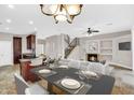 Open-concept living space with a dining area, kitchen island, fireplace, and staircase at 1414 W Coral Reef Dr, Gilbert, AZ 85233