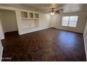 Spacious open-concept living room with tile floors, ceiling fan and a clear view of the front door at 15731 W Evans Dr, Surprise, AZ 85379