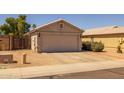 Home exterior featuring a two-car garage, desert landscaping, and a private, fenced side yard at 15737 W Lundberg St, Surprise, AZ 85374