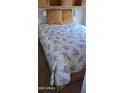 A comfortable bedroom features a bed with a floral quilt, providing a relaxing and inviting atmosphere at 17200 W Bell Rd # 1501, Surprise, AZ 85374