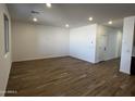 Spacious living room with wood-look tile flooring, recessed lighting, and white walls for a modern feel at 17535 W Fulton St, Goodyear, AZ 85338