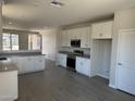Bright, open kitchen featuring white cabinets, stainless steel appliances, and expansive countertops at 18340 W Patrick Ln, Surprise, AZ 85387