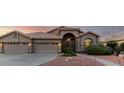 Single-story home with a terracotta roof, arched entry, three-car garage, and desert landscaping at 2058 E Marlene Dr, Gilbert, AZ 85296