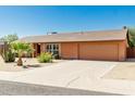 Single story home with well-kept yard, desert landscaping, and a two car garage at 2437 E North Ln, Phoenix, AZ 85028
