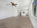 Spacious living room featuring a ceiling fan, and an open floor plan leading into a modern kitchen at 297 W Tamarack Dr, San Tan Valley, AZ 85140