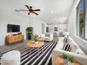 Bright living room with modern furnishings, ceiling fan and a view of the kitchen with white cabinetry at 297 W Tamarack Dr, San Tan Valley, AZ 85140