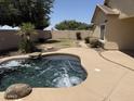 Private backyard oasis featuring a sparkling pool with a rock feature, lush lawn, and mature landscaping at 4523 E Gleneagle Dr, Chandler, AZ 85249