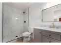 Modern bathroom featuring a walk-in shower with marble tiling, gray vanity, and gold accents at 527 N Pasadena --, Mesa, AZ 85201