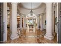 Grand entryway with stone columns, a decorative tiled floor, and a view of the billiards room at 6305 E Arabian Way, Paradise Valley, AZ 85253