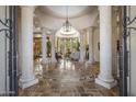 Grand foyer with soaring ceilings, travertine floors with intricate medallion, and stately columns leading to the living area at 6305 E Arabian Way, Paradise Valley, AZ 85253